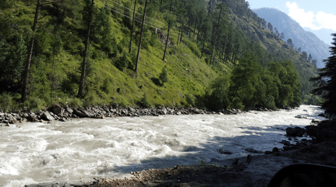 Lush green valley at the background of the Parvati River hurling down